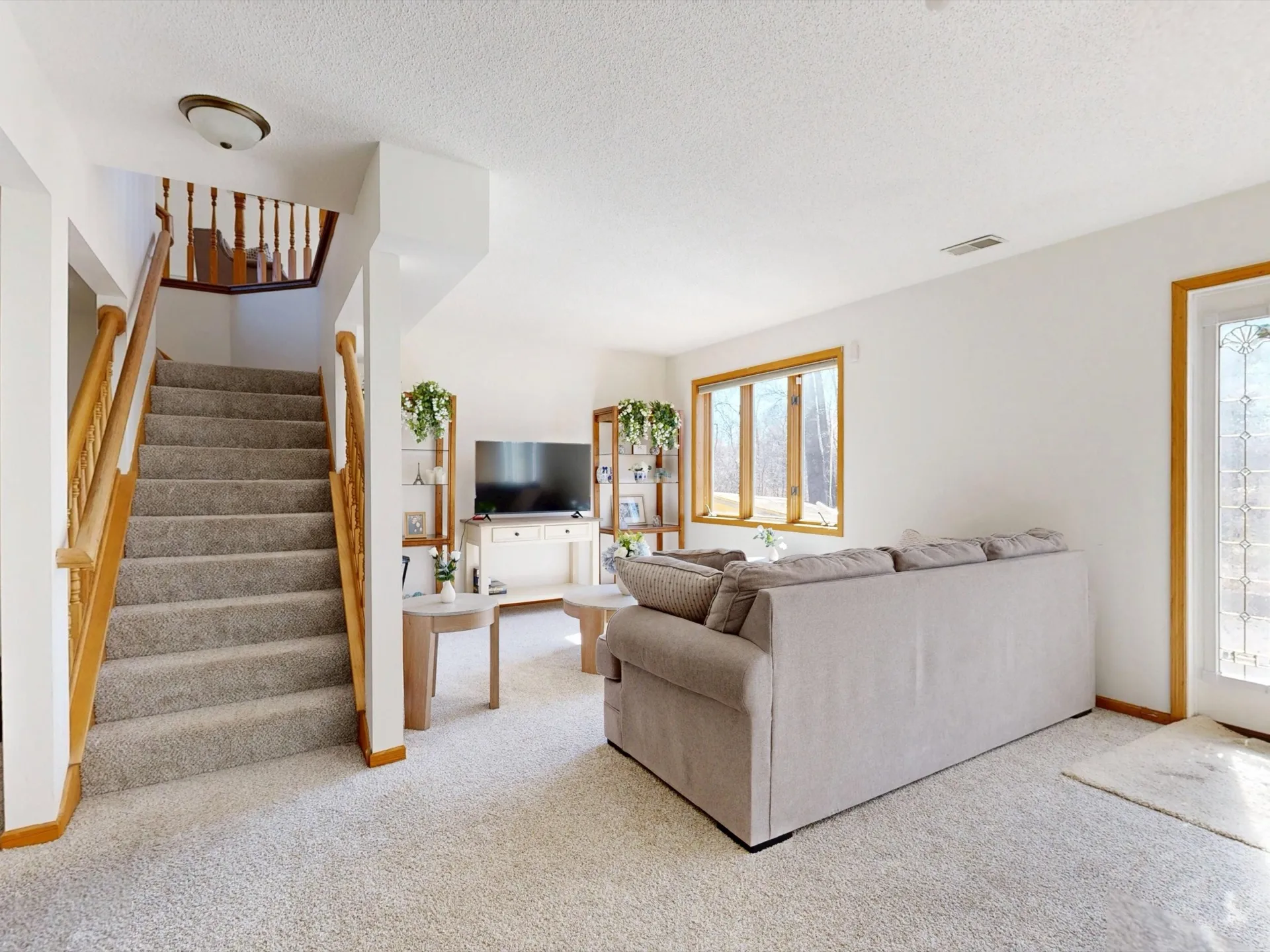 Stainless-steel carpet cleaning wand with hoses on freshly cleaned carpet in a bright living room